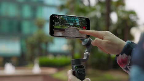 Close-up-shot-of-hand-adjusting-phone-setting-to-record-video-attached-to-gimbal