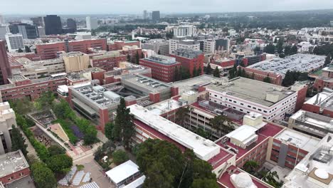 Aerial-view-flying-over-UCLA-campus-blocks-rooftops-in-Los-Angeles,-California-scenic-academic-cityscape