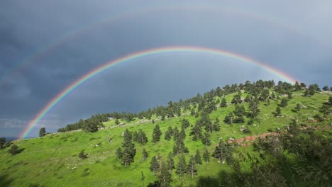 A-rainbow-forming-over-the-hills-of-Boulder,-Colorado,-USA