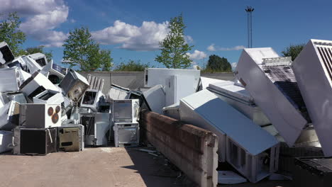 Piles-of-broken-discarded-fridges-and-other-appliances-at-landfill,-slider-right