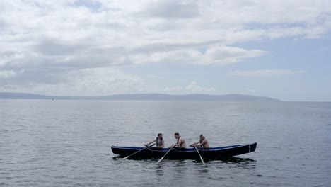 Paddlers-sit-in-currach-boats-practicing-and-communicating-off-coast-of-galway