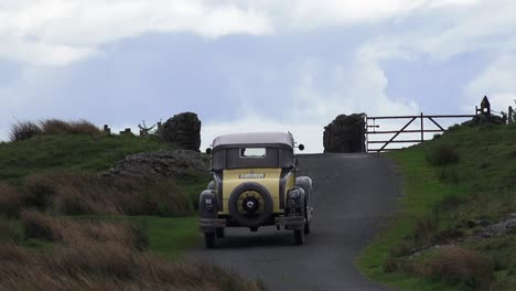 Vintage-car-on-a-bumpy-mountain-road-in-the-Comeragh-Mountains-Waterford-Ireland-on-a-damp-cold-summer-morning