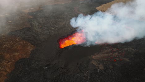 Aerial-panoramic-view-above-the-volcano-erupting-at-Litli-Hrutur,-Iceland,-with-lava-and-smoke-coming-up