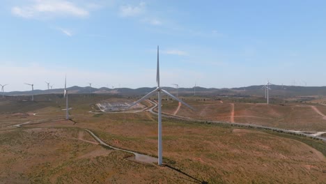 Aerial-orbit-around-wind-turbine-slowly-spinning-to-generate-energy-in-desert