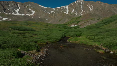 Aerial-cinematic-drone-early-morning-sunrise-hiking-trail-Grays-and-Torreys-14er-Peaks-Rocky-Mountains-Colorado-stunning-landscape-view-mid-summer-green-peaceful-water-steam-forward-pan-up-movement
