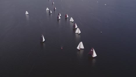 Old-wooden-sail-boats-at-Tjeukemeer-Friesland-sailing-a-race,-aerial