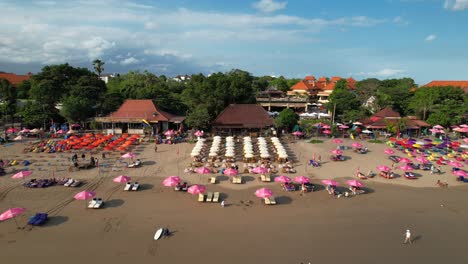 Double-Six-Strand-Mit-Vielen-Leihschirmen-Zum-Sonnenbaden-–-Freizügige-Push-Back-Aufnahme-Aus-Der-Luft,-Bali,-Indonesien