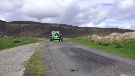A-vintage-car-at-speed-on-a-high-mountain-pass-on-a-vintage-car-rally-based-in-Waterford-Ireland-on-a-bright-summers-day