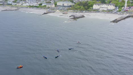 Das-Zurückziehen-Der-Drohne-Nach-Oben-Zeigt-Boote-An-Der-Küste-Von-Galway-Und-Currach,-Die-Vor-Dem-Ladies-Beach-Rasen