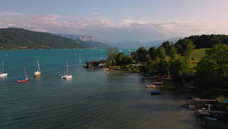 Blue-lake-Attersee-in-Austria-with-clear-water,-sailing-ship-boat-and-alps-mountains-near-idyllic-scenic-Wolfgangsee,-Mondsee-close-to-famous-Mozart-city-Salzburg