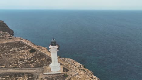 Fliegen-Auf-Einen-Leuchtturm-Auf-Einer-Trockenen-Felsklippe-Mit-Blick-Auf-Das-Mittelmeer-Zu