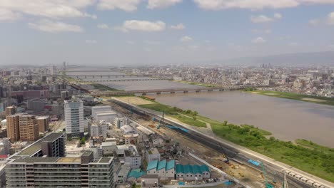 Amazing-wide-aerial-of-Yodo-River-with-skyline,-skyscraper,-and-city-in-Osaka,-Japan