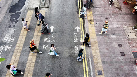 Draufsicht-Auf-Eine-Maskierte-Menschenmenge,-Die-Während-Der-Covid-19-Pandemie-Eine-Straße-In-Hongkong-überquert