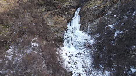 Couple-of-climbers-with-backpack-walking-towards-a-frozen-waterfall