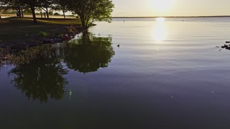 Reflective-lake-water-at-golden-hour-in-Rockwall,-Texas