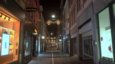 Leere-Dekorierte-Einkaufsstraße-In-Maastricht-Bei-Nacht-Mit-Beleuchteten-Schaufenstern