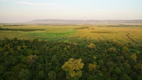 Africa-Aerial-Shot-from-Hot-Air-Balloon-Ride-Flight-of-Beautiful-Masai-Mara-Savanna-and-Forest-Landscape-in-Kenya,-Flying-Over-Amazing-African-Scenery,-View-From-Above-Flying-Over-Nature