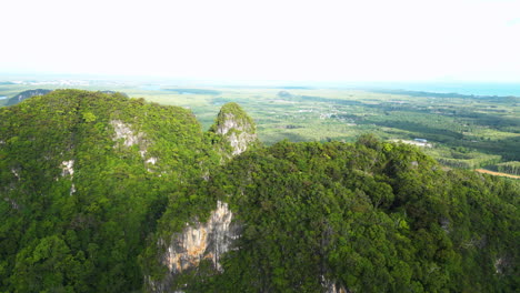 Rocky-mountains-overgrown-in-green-lush-jungle-in-Thailand,-aerial-view