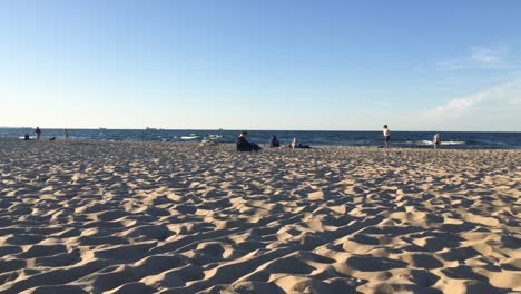 Westerplatte-Strand-In-Der-Nähe-Von-Danzig-Im-Norden-Polens-Mit-Menschen,-Die-Sich-Bei-Sonnenuntergang-Entspannen-Und-Laufen