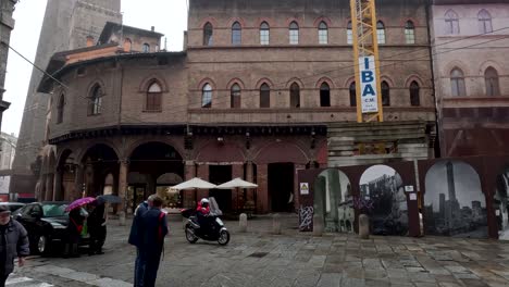 Öffentlicher-Gelenkbus-Fährt-In-Bologna-Entlang-Der-Piazza-Della-Mercanzia-Vorbei,-5-An-Einem-Regnerischen-Tag