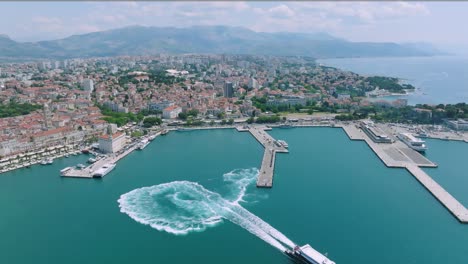 Wide-aerial-pull-out-of-ferry-leaving-from-harbor-in-Split,-Croatia