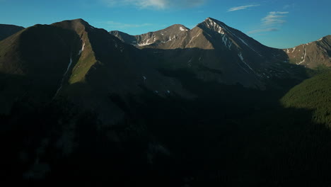 Aerial-cinematic-drone-sunrise-sunlight-early-morning-shadows-Grays-and-Torreys-14er-Peaks-Rocky-Mountains-Colorado-stunning-landscape-view-mid-summer-snow-on-top-forward-pan-up-movement