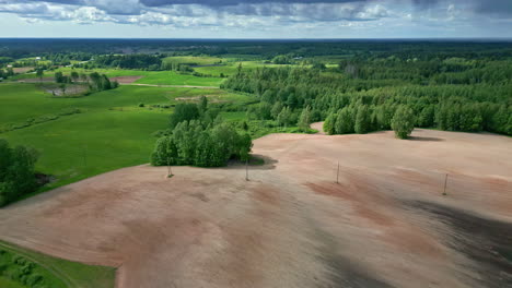 Arable-soil-and-green-landscape-of-rural-countryside,-aerial-view