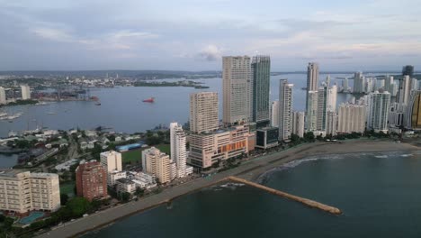 Aerial-along-the-Playa-De-Bocagrande-beaches-and-skyscrapers-at-dusk-in-Cartagena,-Boliviar,-Colombia