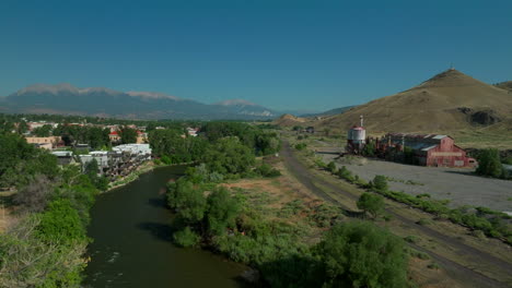 Aerial-cinematic-drone-mid-summer-downtown-Salida-S-Lime-Mill-Colorado-near-Buena-Vista-on-Arkansas-River-Riverside-Park-Scout-surfing-wave-biking-hiking-rafting-Rocky-Mountain-backward-movement