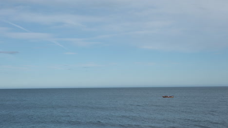 Distant-View-Of-Sailing-Boat-In-Serene-Ocean-Near-Norway-Coastline