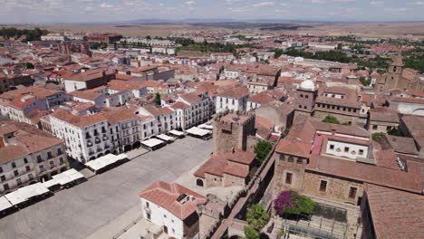 Aerial-orbit-around-empty-city-square-and-Torre-de-Bujaco-in-Caceres,-Spain