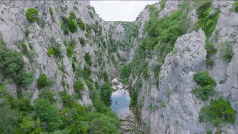 Aerial-dolly-shot-pulling-back-along-the-Cetina-river,-Croatia-revealing-series-of-small-waterfalls