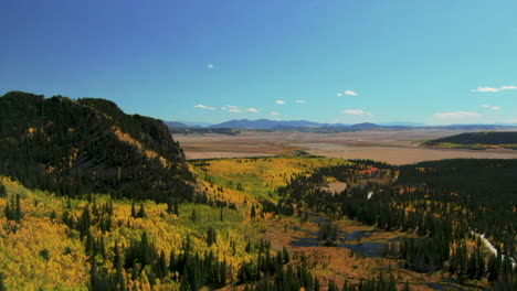 Fall-colors-in-Colorado-cinematic-aerial-drone-Aspen-trees-yellow-gold-orange-green-turning-of-seasons-autumn-bluebird-sunny-afternoon-stunning-peaceful-mountain-lake-Jefferson-FairPlay-back-movement