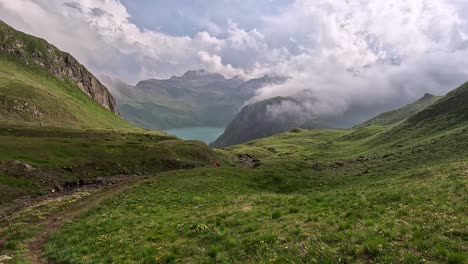 Green-alpine-meadows-and-hills-surrounding-lago-vanino-a-turquoise-lake-in-the-alps-of-north-italy