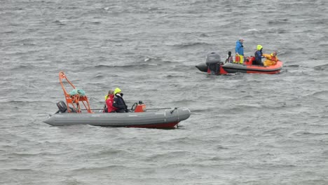 Telephoto-view-of-support-crew-in-inflatable-boat-dinghies-in-open-ocean-at-boating-event