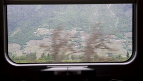 Fensterblick-In-Einem-Zug,-Der-Durch-Die-Berglandschaft-Der-Schweiz-Fährt