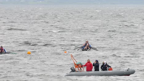 Currach-boat-racer-approaches-start-line-buoys-in-galway-bay-in-front-of-safety-team