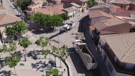 Aerial-orbit-around-trucks-and-roadwork,-construction-site-in-Navas,-Spain