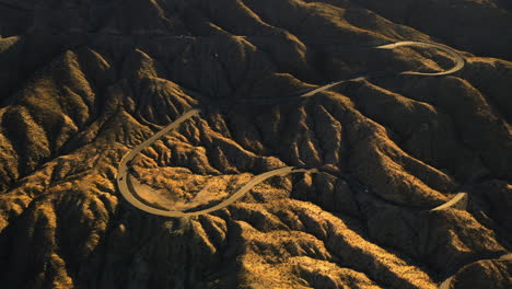 Aerial-view-of-traffic-on-a-winding-mountain-road,-golden-hour-in-Arizona,-USA