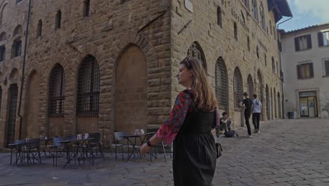A-young-woman-walking-through-the-old-walled-town-of-Volterra,-Province-of-Pisa,-Italy