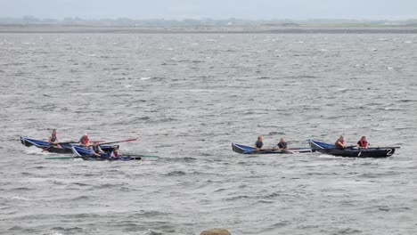 Currach-boats-race-through-water-in-open-ocean-in-slow-motion