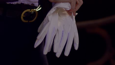 Cinematic-Slow-Motion-Shot-of-woman-putting-on-white-horse-riding-gloves,-Close-Up-Slomo