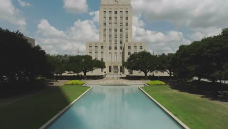 Vista-Aérea-Por-Drones-Del-Edificio-Del-Ayuntamiento-De-Houston-Y-La-Piscina-Reflectante-En-El-Centro-De-Houston,-Texas