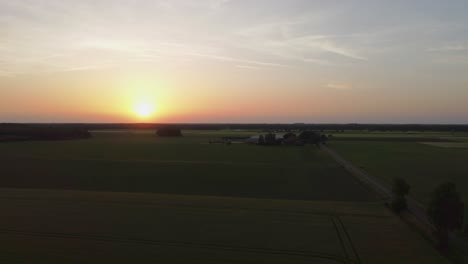 Beautiful-golden-sunset-in-the-Netherlands-over-green-farmland,-aerial