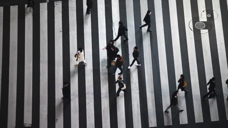 People-walking-over-the-famous-Shibuya-crossing,-in-Tokyo,-Japan---static-view