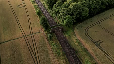 Aerial-View-Of-Railway-Along-The-Fields-With-Crops-In-Warminster,-UK