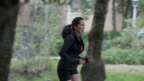 a-woman-dressed-all-in-black-doing-a-morning-sprint-in-a-city-park