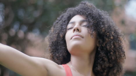 Close-up-shot-Curly-haired-girl-doing-yoga-on-the-edge-of-the-city-park-in-the-morning