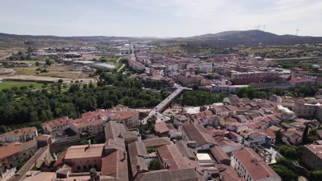 Aerial:-Catedral-Nueva-de-Plasencia-overlooks-Trujillo-bridge,-Spain