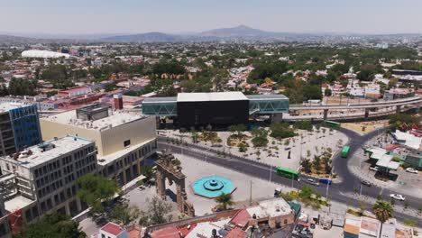 Orbiting-drone-view,-downtown-train-station-and-tracks,-Zapopan-Metro,-Mexico